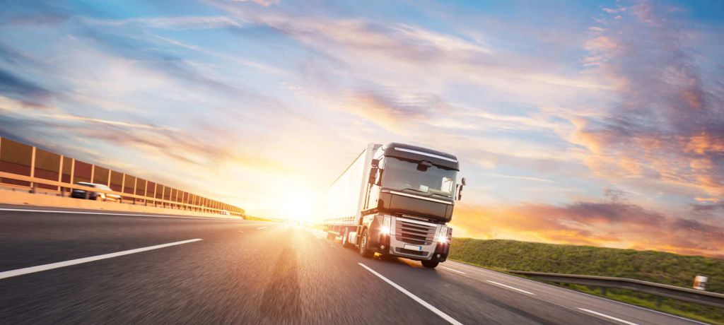 Lkw fährt bei Abenddämmerung auf einer Autobahn - Umzug Transport